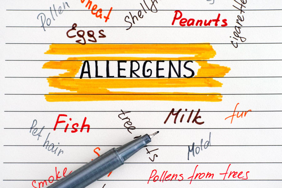 Food Allergens on a notepad with a pen