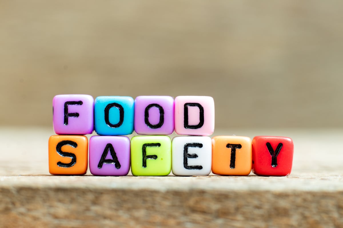 Colorful bead with black letter in word food safety on wood background