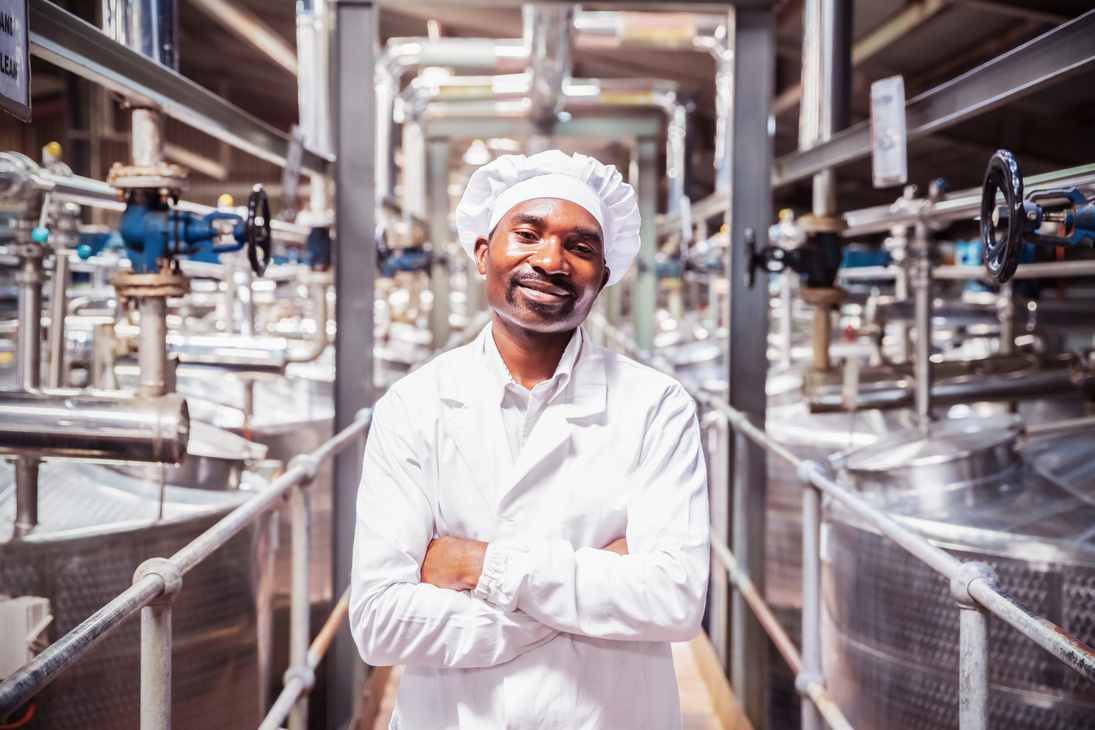 Food factory Supervisor/ manager standing in a white coat in the food factory.