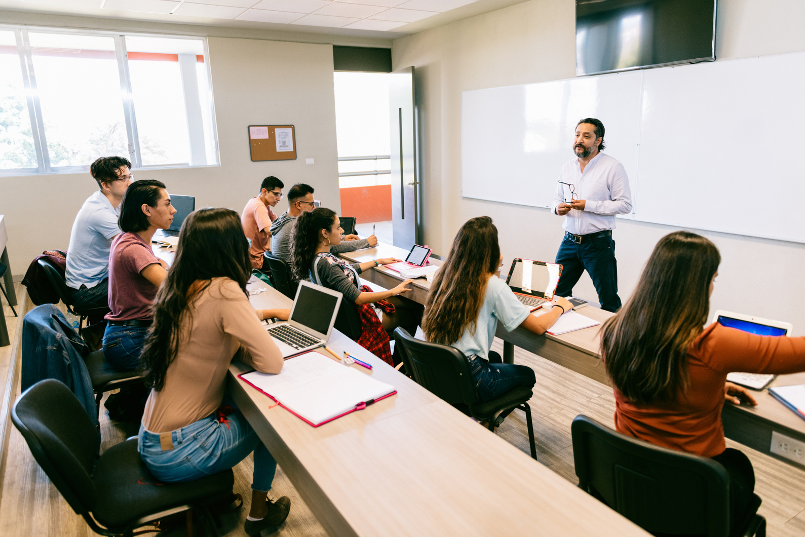 a Food Safety Training provider standing in front of a group of students who happen to be food handlers/ chefs/ supervisors in food factories in a classroom, conducting food safety training